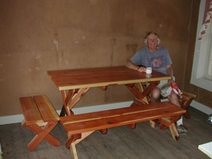 Photo - Steve Harper sits at table made by Glen Haslett.